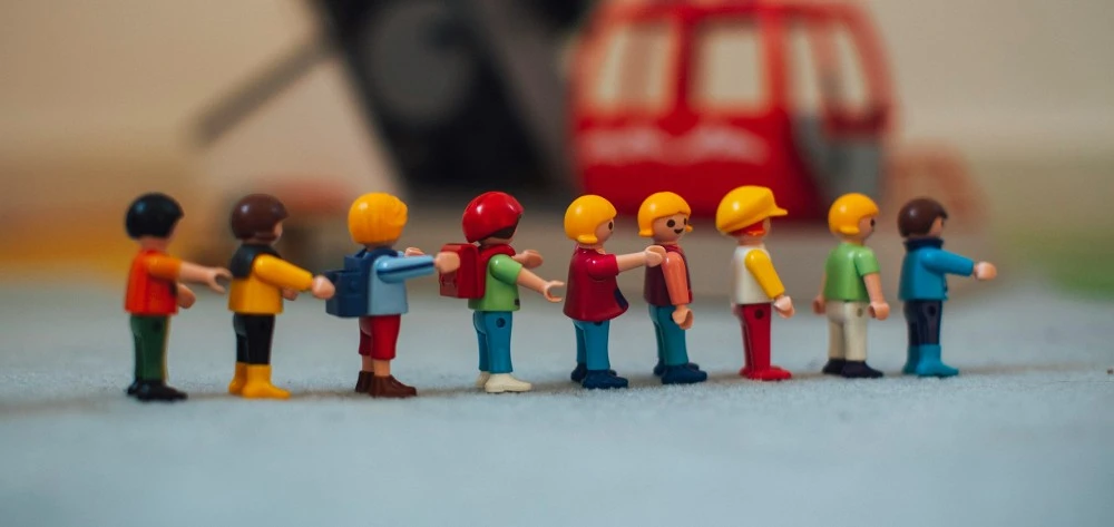 Children's play figures arranged in a neat line